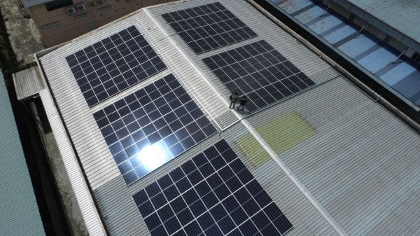 工人在屋頂上安裝大陽能光伏發電系統。
