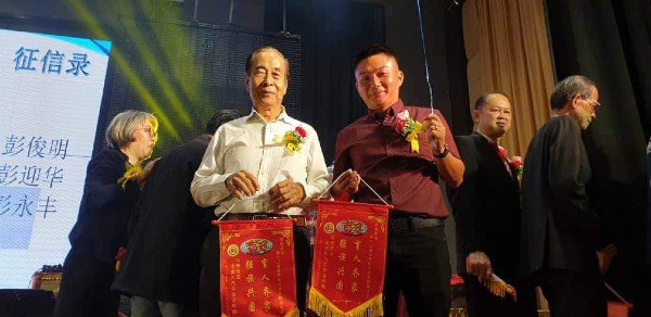 彭業偉（右）陪同祖父彭亮中（左）参与彭氏公会活动。