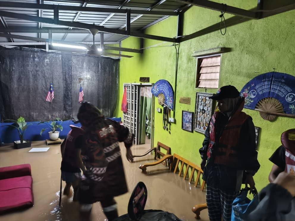 消拯员赶往哥打丁宜甘榜峇鲁双溪玛斯一间民宅，协助将居民疏散至安全地点。