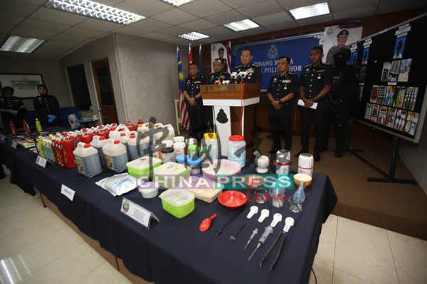 拉哈曼（台上左3）展示警方所起获的毒品包装、含毒品的“凉茶罐”及各种毒品加工包装工具。