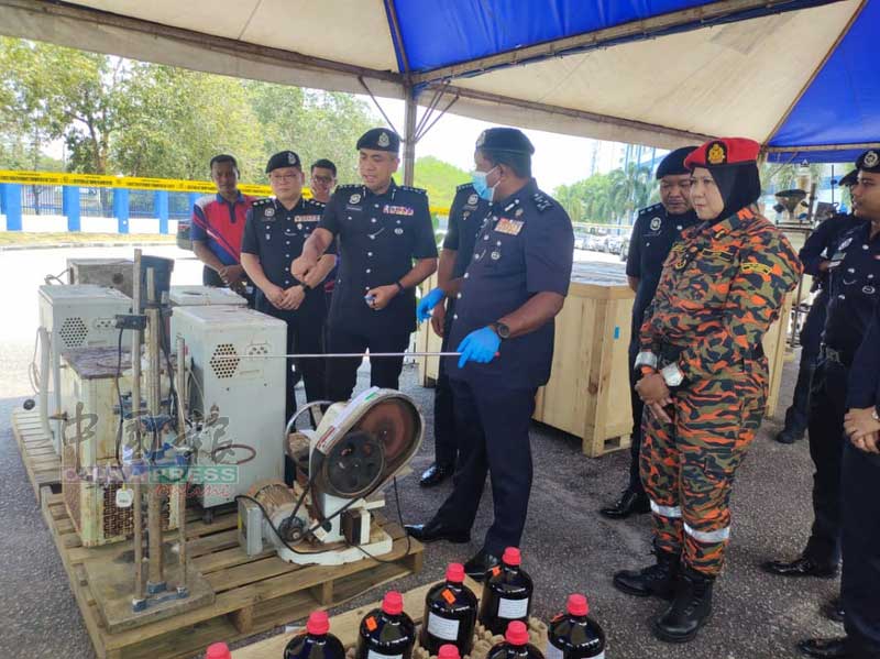 陈胜利（左2起）、马沙尼陪同胡仙展示制毒机械。