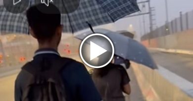 上班高峰期下大雨 马劳撑伞步行越堤